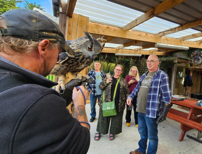 Man holding large owl at sanctuary.