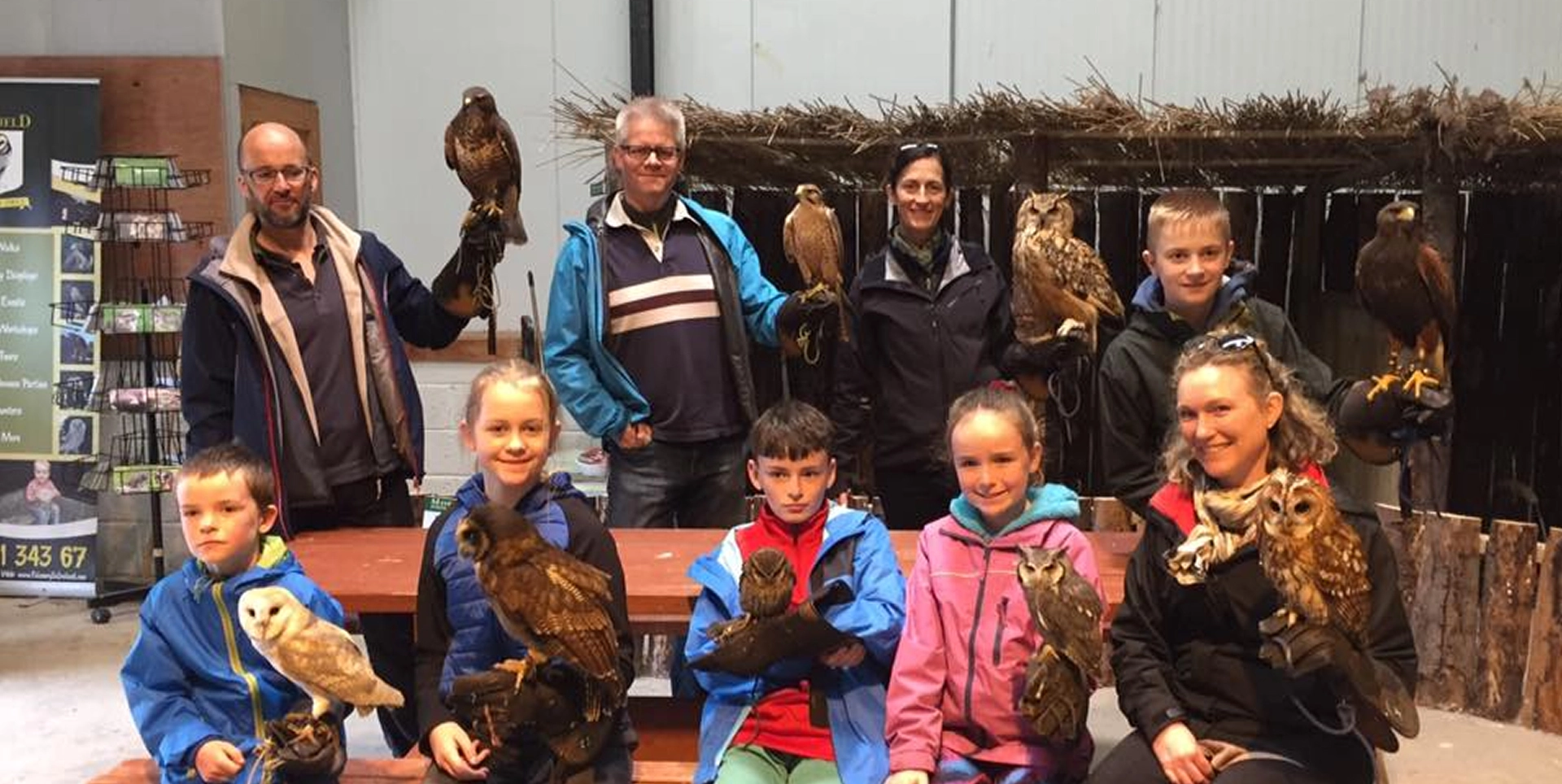 Group holding various owls and hawks.