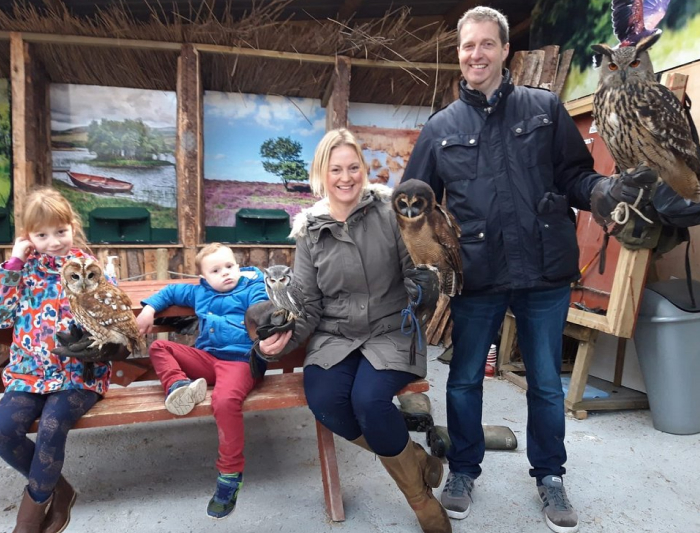 Family posing with several different owls.